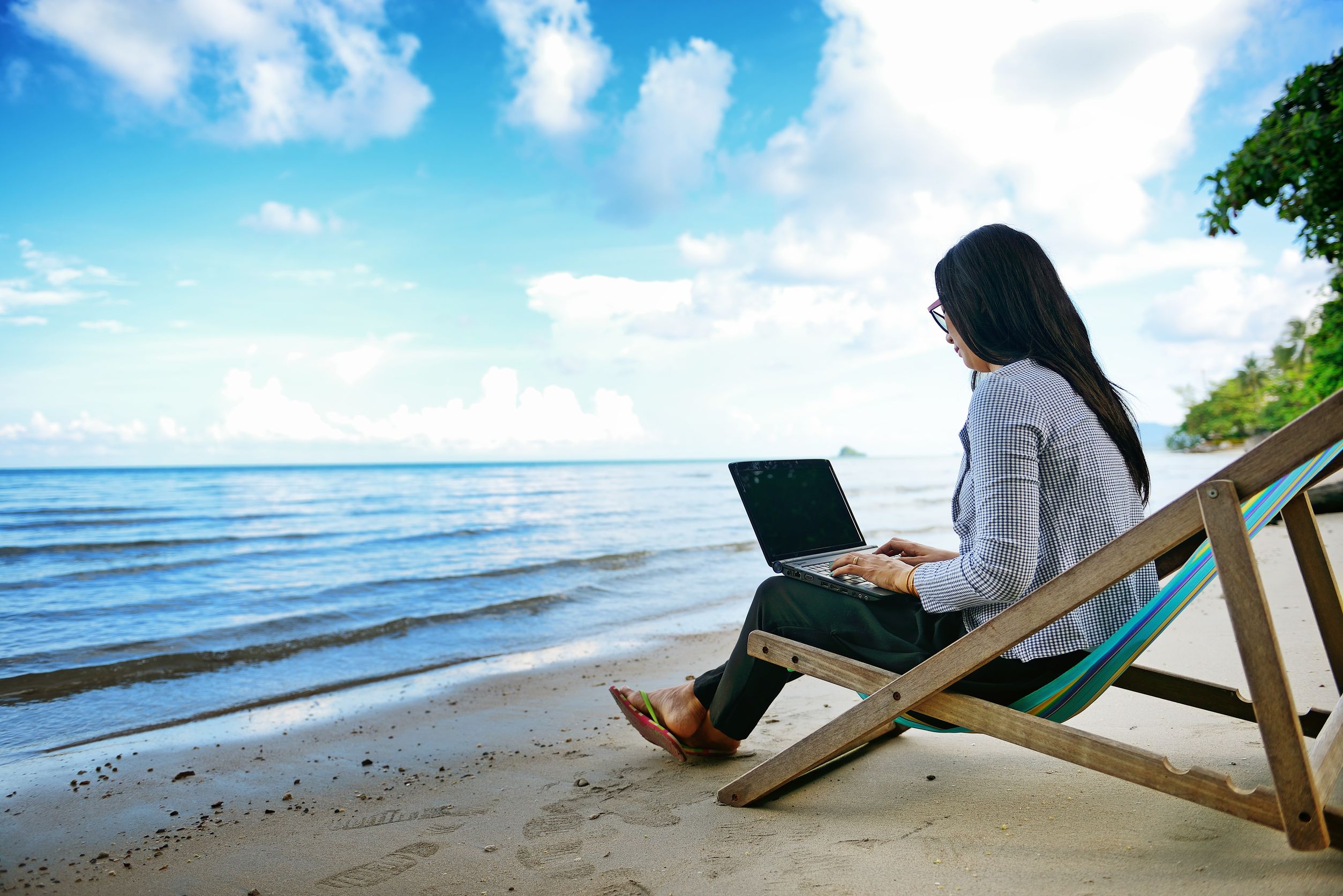 Удаленный фрилансер. Человек с ноутбуком на пляже. Девушка с ноутбуком на пляже. Ноутбук на природе. С ноутбуком на море.
